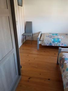 ペロルにあるVilla climatisée proche mer Carnon Pérolsのベッドルーム1室(ベッド1台、椅子付)が備わります。