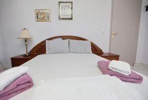a white bed with two towels on top of it at DIANA'S HOUSE in Khrisókastron