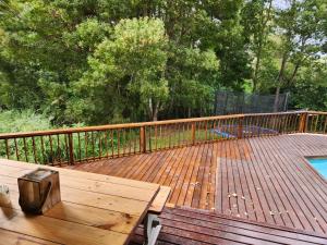 a wooden deck with a picnic table and a pool at Knysna Holiday Armadillo in Knysna