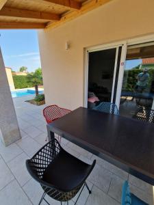 - une table et des chaises noires sur la terrasse dans l'établissement Villa Providenca Volme Hrvatska, à Banjole