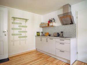 a kitchen with white cabinets and a wooden floor at Sommerfrische Lychen in Lychen