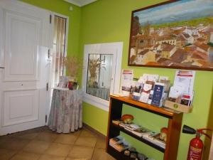 a room with green walls and a painting on the wall at Hostal Ciudad de Nájera in Nájera