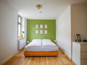 a bedroom with a bed and a green wall at Sommerfrische Lychen in Lychen