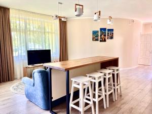 a living room with a table and stools at АВІА in Uzhhorod