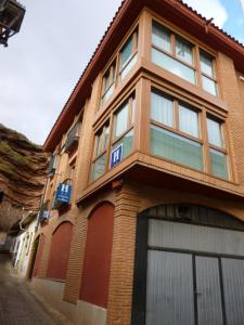 um edifício de tijolos castanhos com janelas numa rua em Hostal Ciudad de Nájera em Nájera