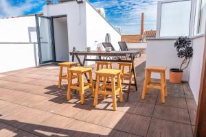 a patio with a wooden table and stools at Beach & Sea Guesthouse in Espinho