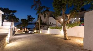 un árbol delante de un edificio por la noche en Villa Maria - Seashore Serenity Villa at Myrties Beach Kalymnos, en Myrties