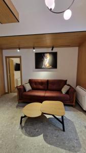 een woonkamer met een bruine bank en een salontafel bij FS Apartments - Wonderful apartment in the top center of Varna in Varna
