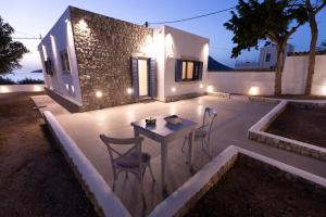 un patio con mesa y sillas frente a una casa en Villa Maria - Seashore Serenity Villa at Myrties Beach Kalymnos, en Myrties