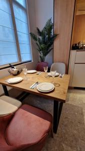een houten tafel met borden en wijnglazen erop bij FS Apartments - Wonderful apartment in the top center of Varna in Varna