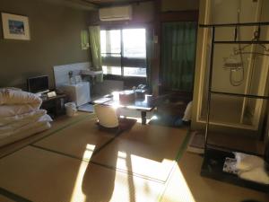 Komecho Ryokan في إيمباري: غرفة معيشة مع لاب توب على الأرض