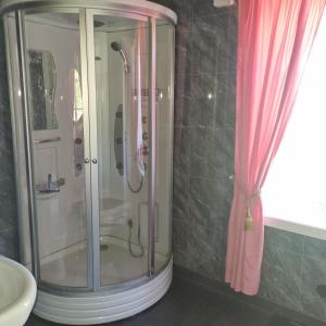 a shower in a bathroom with a pink shower curtain at Paradiset in Hammarland