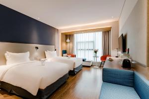 een hotelkamer met 2 bedden en een televisie bij Holiday Inn Express Taian City Center, an IHG Hotel in Tai'an
