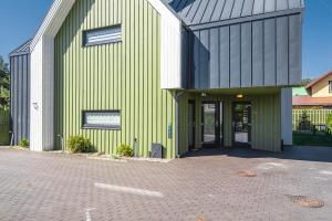 a green and white building with a door at Žalia kopa in Palanga