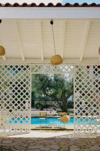 a screened in patio with a table and chairs at Oliva Holiday Homes in Dhiyeliótika