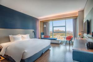 een hotelkamer met een groot bed en een bureau bij Holiday Inn Express Taian City Center, an IHG Hotel in Tai'an