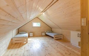 a room with two beds in a wooden house at Ostoja Sosnowa Czarny Mlyn, kompleks dwóch domkow in Czarny Młyn