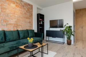 un soggiorno con divano verde e parete in mattoni di Grójecka Studio for 3 guests with Balcony Warsaw by Renters a Varsavia