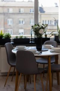 un tavolo con sedie e un vaso di fiori sopra di Grójecka Studio for 3 guests with Balcony Warsaw by Renters a Varsavia