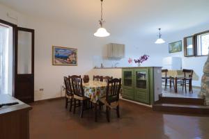 a kitchen and dining room with a table and chairs at Trullo - Cantoru in Marina di Pescoluse