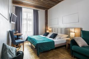 Habitación de hotel con cama y sofá verde en Aparthotel Pergamin, en Cracovia