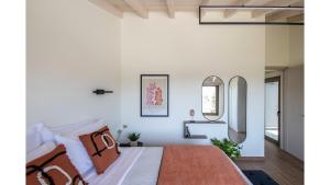 a bedroom with a bed and a mirror at Salina SPA Villas - with PRIVATE HEATED ECO-POOL, SAUNA & JACCUZI HOT TUB in Volos