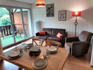a living room with a table and a couch at Balcon plein sud, piscine/spa in Luz-Saint-Sauveur