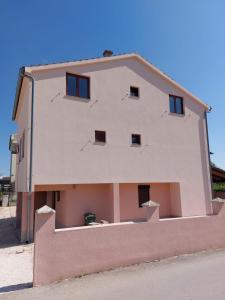 a large white building with windows on the side of it at Apartmani Ana in Sukošan