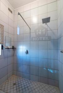 uma casa de banho com um chuveiro e uma porta de vidro em N1 Hotel Samora Machel Harare em Harare