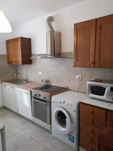 cocina con lavadora y microondas en Bluelake Apartment 3 Omegna en Omegna