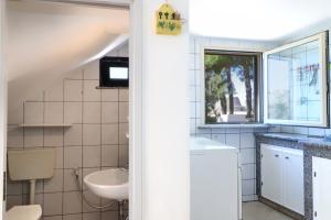 a bathroom with a sink and a toilet and a window at Trullo - Cantoru in Marina di Pescoluse