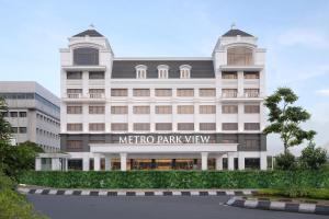 un gran edificio blanco con un letrero que lee "Metro Parkview" en Metro Park View Hotel Kota Lama Semarang, en Semarang