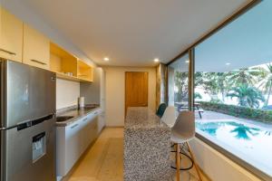 an open kitchen with a view of a swimming pool at 2062 - Lu Iba Condo 1 in Santa Cruz Huatulco