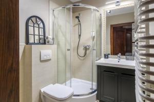 een badkamer met een douche, een toilet en een wastafel bij Aparthotel Pergamin in Krakau