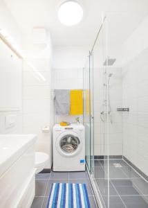 a white bathroom with a washing machine in a shower at FEEL HOME Superior-FREE PARKING-BALCONY-AC-Elevator in Budapest