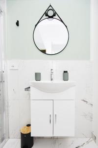 uma casa de banho com um lavatório branco e um espelho. em MILANO URBAN FLATS Modern apartments few minuts from Duomo em Milão