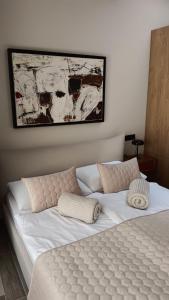 ein Bett mit weißer Bettwäsche und Kissen in einem Schlafzimmer in der Unterkunft Sun city lifestyle in Poreč