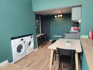 a kitchen with a washing machine and a table at Three Cities Guest House in Cospicua