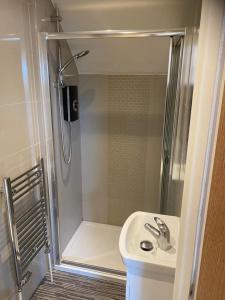 a small bathroom with a shower and a sink at Cosy Loft Apartment Just Off Vibrant Mill Rd Cb1 in Cambridge