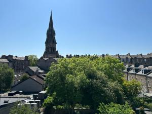 a view of a city with a church steeple in the background at The Valentine - Townhouse Hotel in Edinburgh