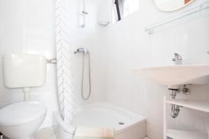 a white bathroom with a toilet and a sink at Dubasa B&B in Vantačići