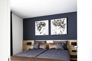 ein Schlafzimmer mit einem Bett mit zwei Bildern an der Wand in der Unterkunft Villa Infinity - Luxurious seaview Villa with enchanting Pool in Kali