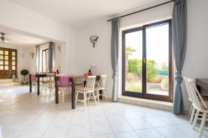 a dining room with a table and chairs and a large window at Dubasa B&B in Vantačići