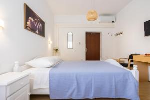 a white bedroom with a bed with a blue blanket at Dubasa B&B in Vantačići