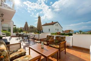 a patio with a table and chairs and an umbrella at Dubasa B&B in Vantačići