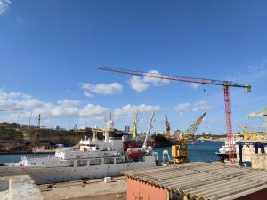 a cruise ship docked in a harbor with cranes at Three Cities Guest House in Cospicua