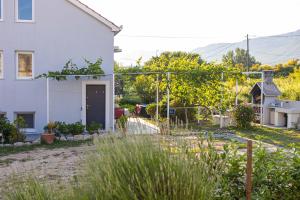un giardino di fronte a una casa bianca di Soba sa kupaonicom a Solin (Salona)