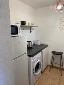 a kitchen with a washing machine and a microwave at Appartement Marseille 12 Calme transport à proximité. in Marseille