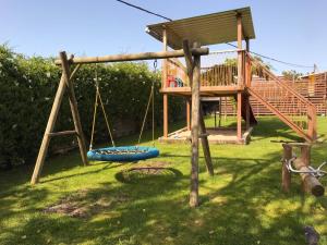 a playground with a swing and a tree house at Cantabria Collection - Espectacular casa con piscina y jardín in Oruña