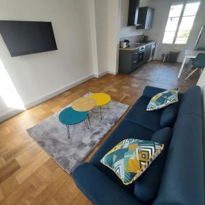 a living room with a blue couch and a table at Appartemement F2 refait à neuf hyper centre in Coutances +3 photos